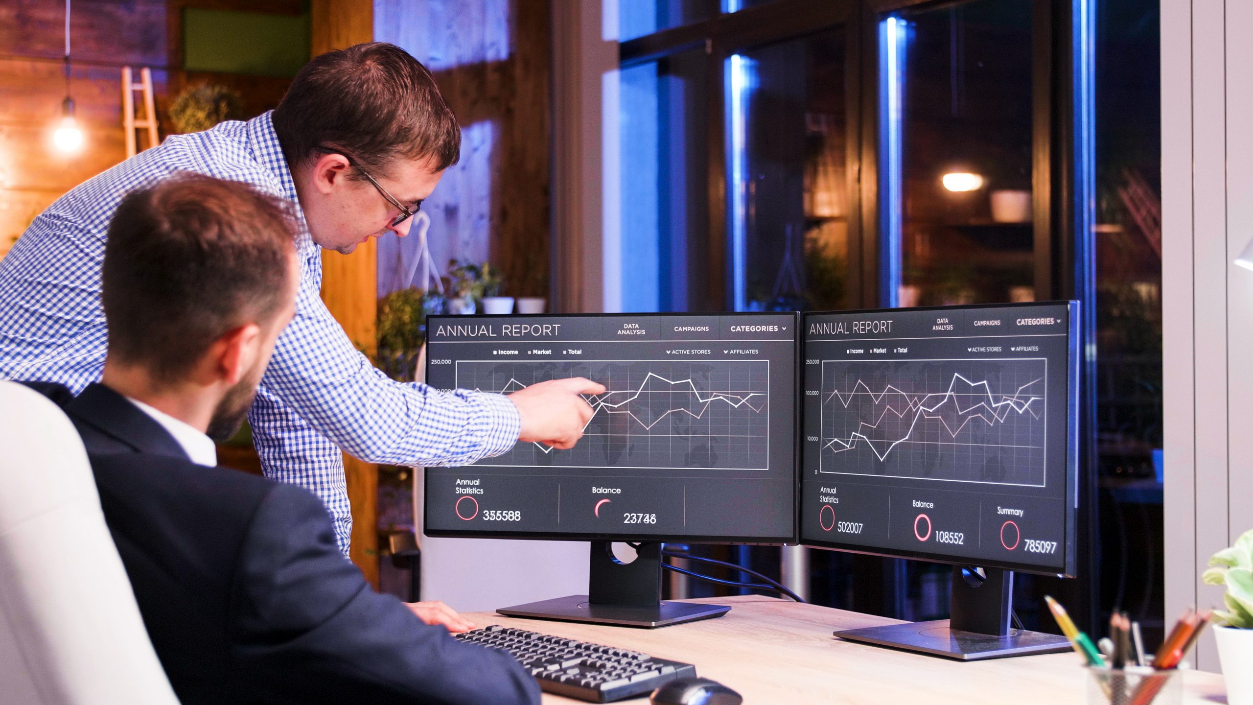 Two colleagues working late office blue light night view scaled